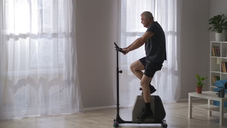 modern-stationary-bicycle-in-homeadult-man-is-training-on-gym-equipment-losing-weight-and-keeping-good-physical-condition